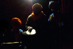 Gnawa musicians playing drums in the desert near Khamlia