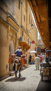 Narrow lane in the Fes medina with a porter carrying goods
