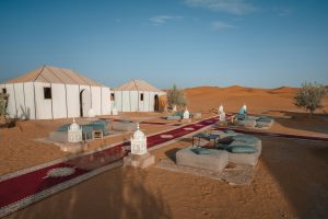 Campamento en el desierto con alfombras y jaimas entre las dunas de Erg Chebbi